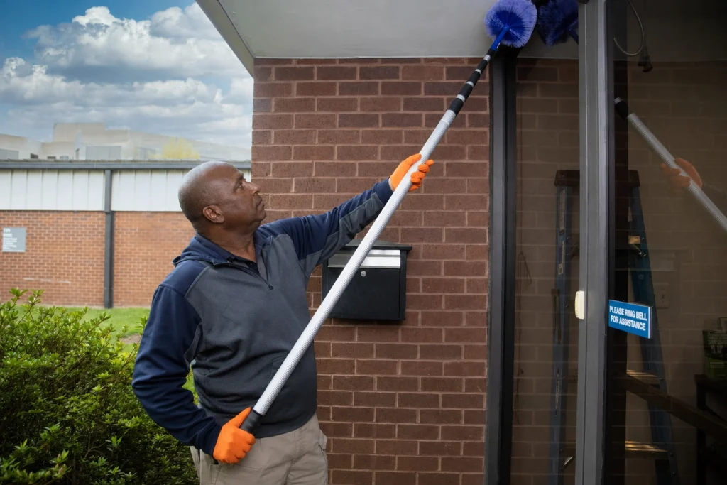 Technician de-webbing the exterior of a commercial building