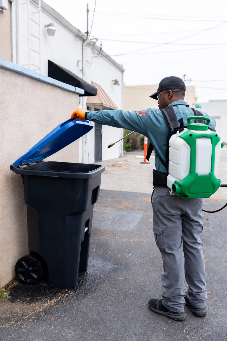 Technician treating a commercial waste and dumpster area