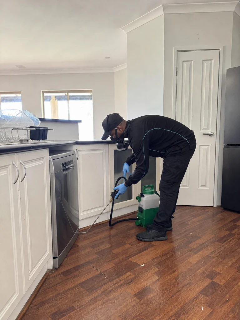 Technician performing indoor pest control service in a home