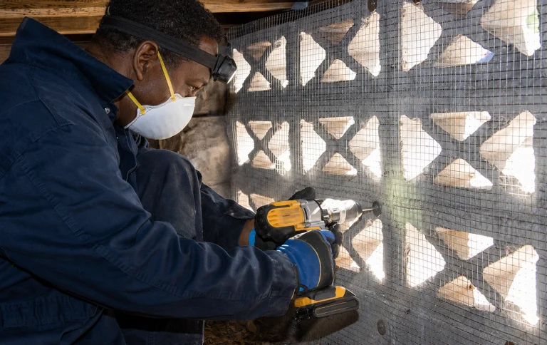 Technician installing rodent exclusion material